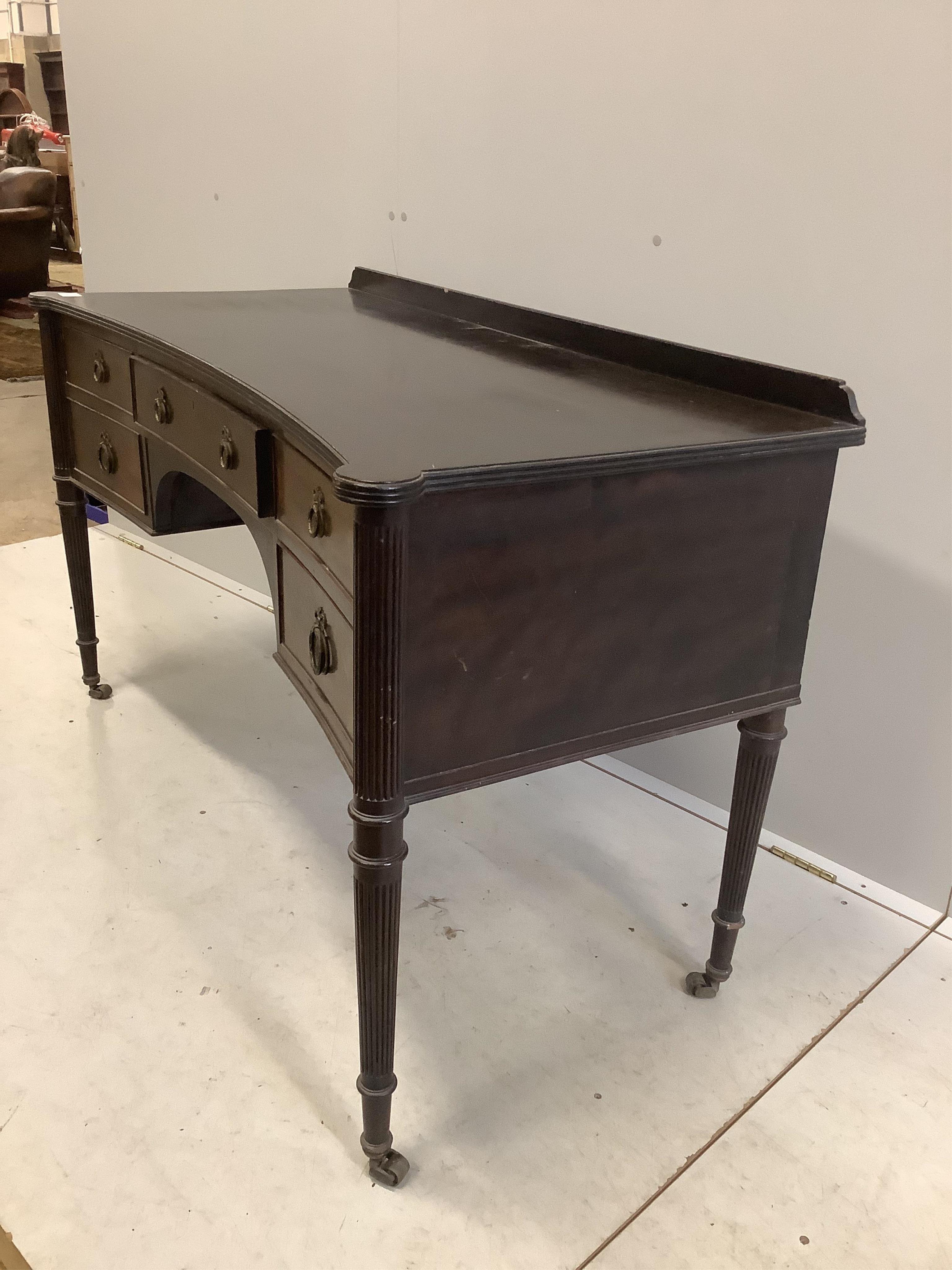 An early 20th century mahogany concave kneehole dressing table, width 136cm, depth 60cm, height 78cm. Condition - fair